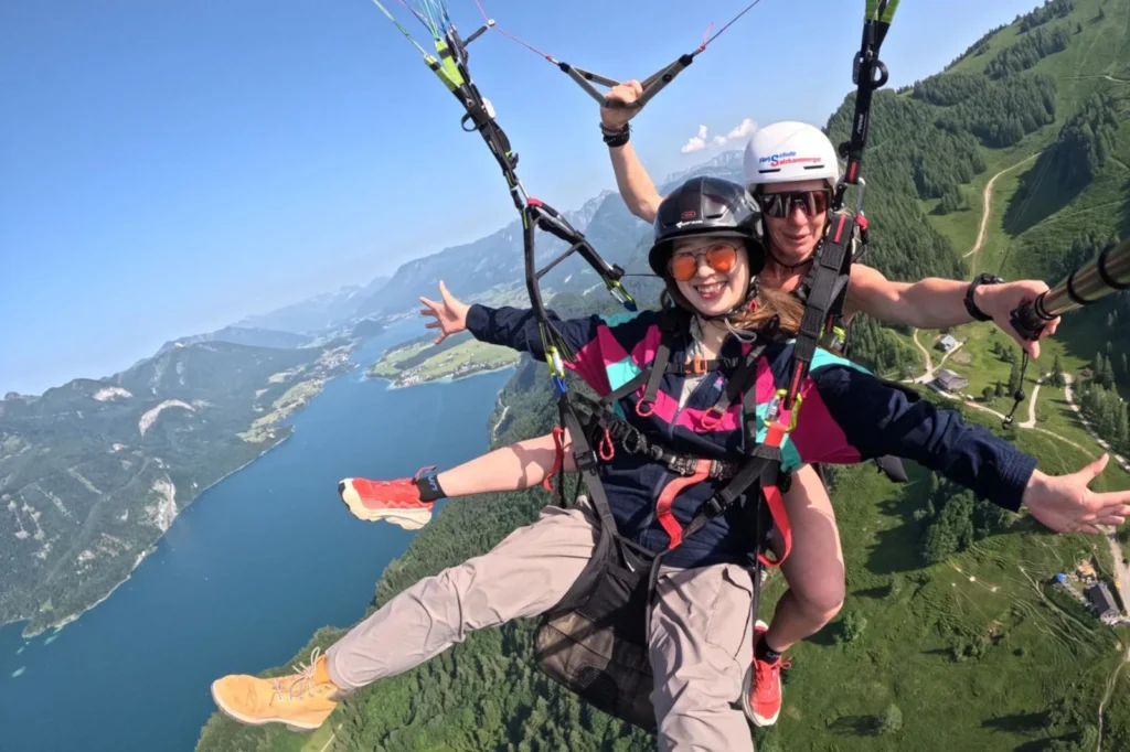 Tandempilotin und Passagierin beim Tandemflug über dem Wolfgangsee – Paragleiten im Salzkammergut