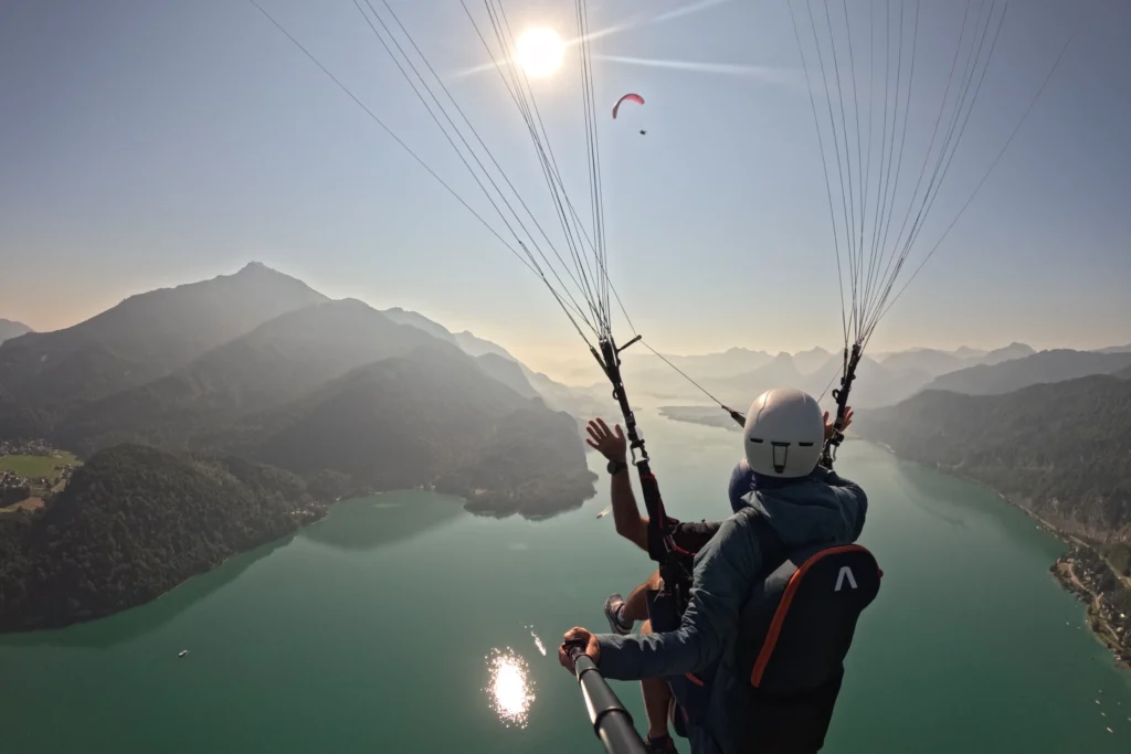 Morgenflug beim Tandemflug über dem Wolfgangsee – Blick von hinten auf Pilot und Passagier im Salzkammergut