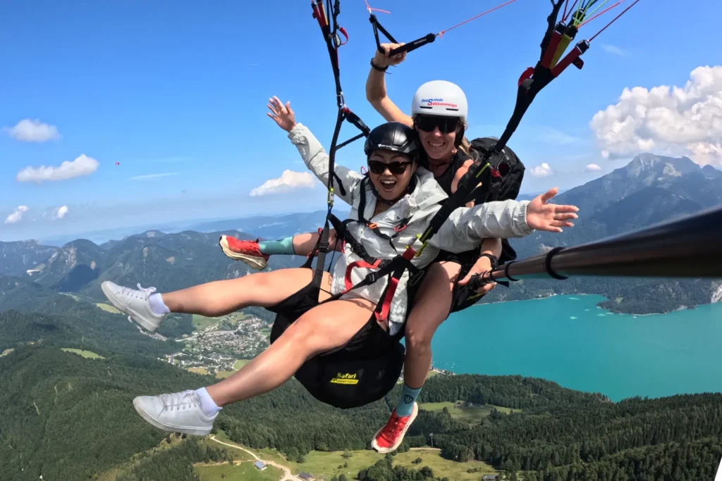 Jubelnde Passagierin beim Tandemflug – Paragleiten über dem Wolfgangsee im Salzkammergut